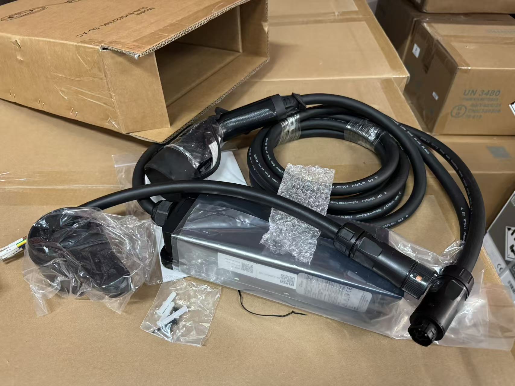 Deye Smart Wallbox mit Ladekabel und Zubehör auf Kartonhintergrund.